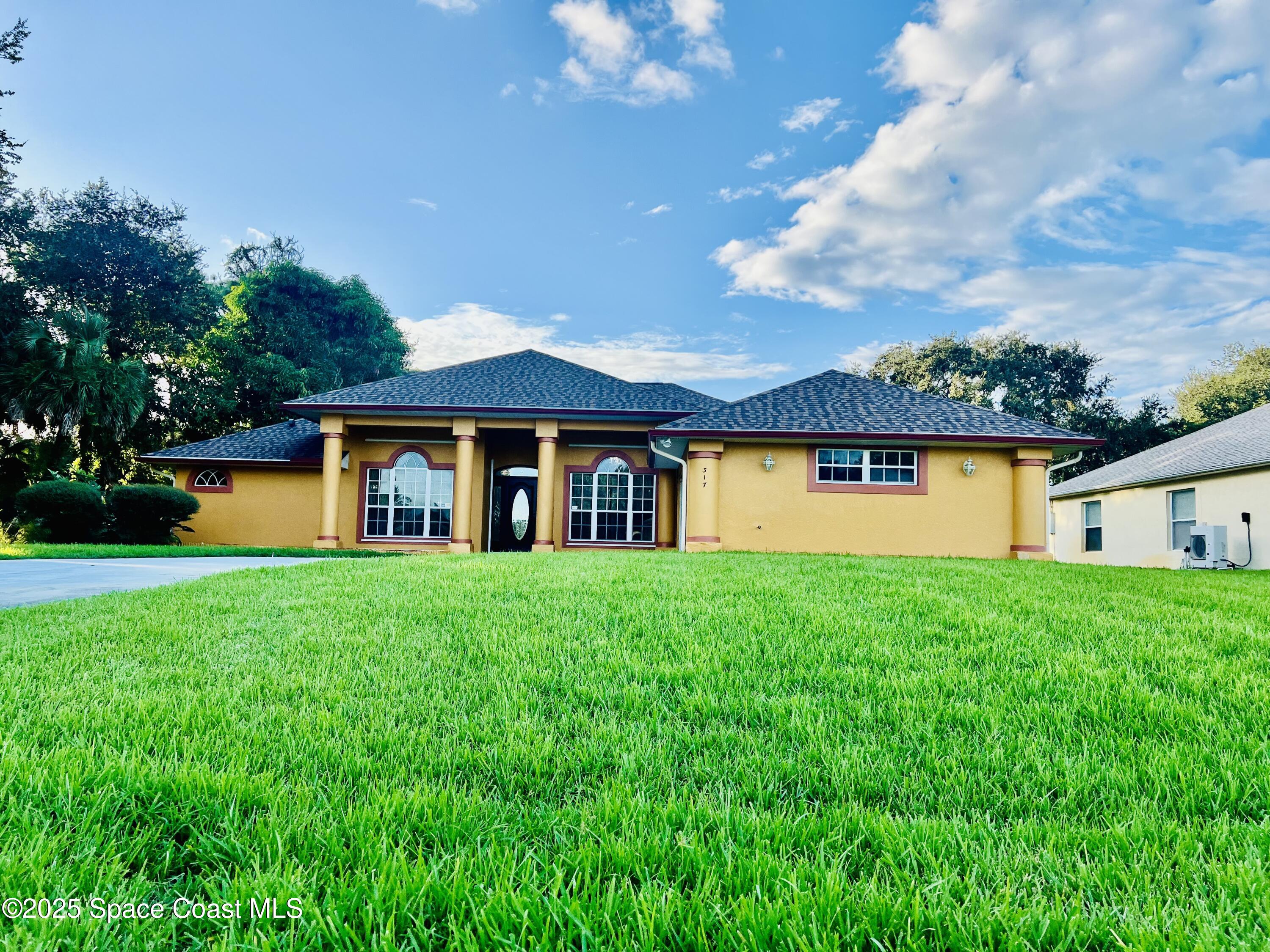 317 Lanack Road Southeast Palm Bay, FL 32909 - Photo 3 of 37 a front view of a house with a yard