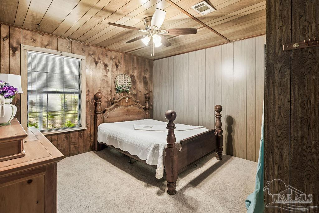 8938 Pioneer Road Holt, FL 32564 - Photo 25 of 44 a bed sitting in a bedroom next to a window