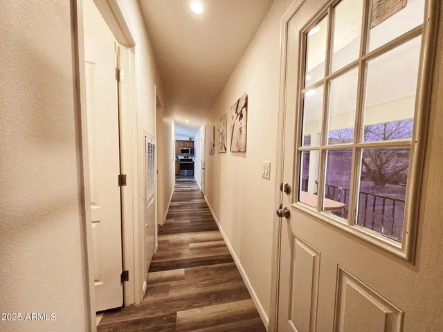 a kitchen with a refrigerator a stove a sink dishwasher a dining table and chairs with wooden floor