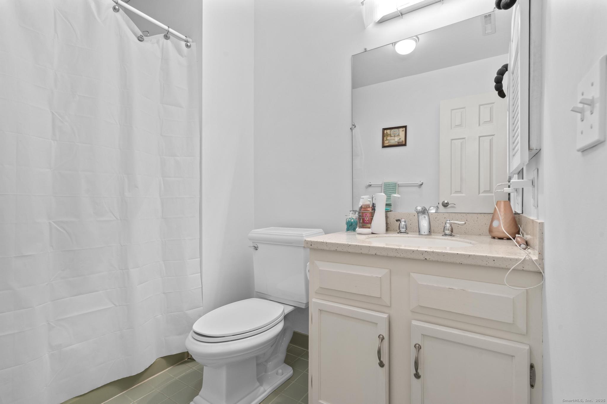 15 Derbyshire, Unit 15 Derby, CT 06418 - Photo 24 of 39 a bathroom with a sink a toilet and a mirror