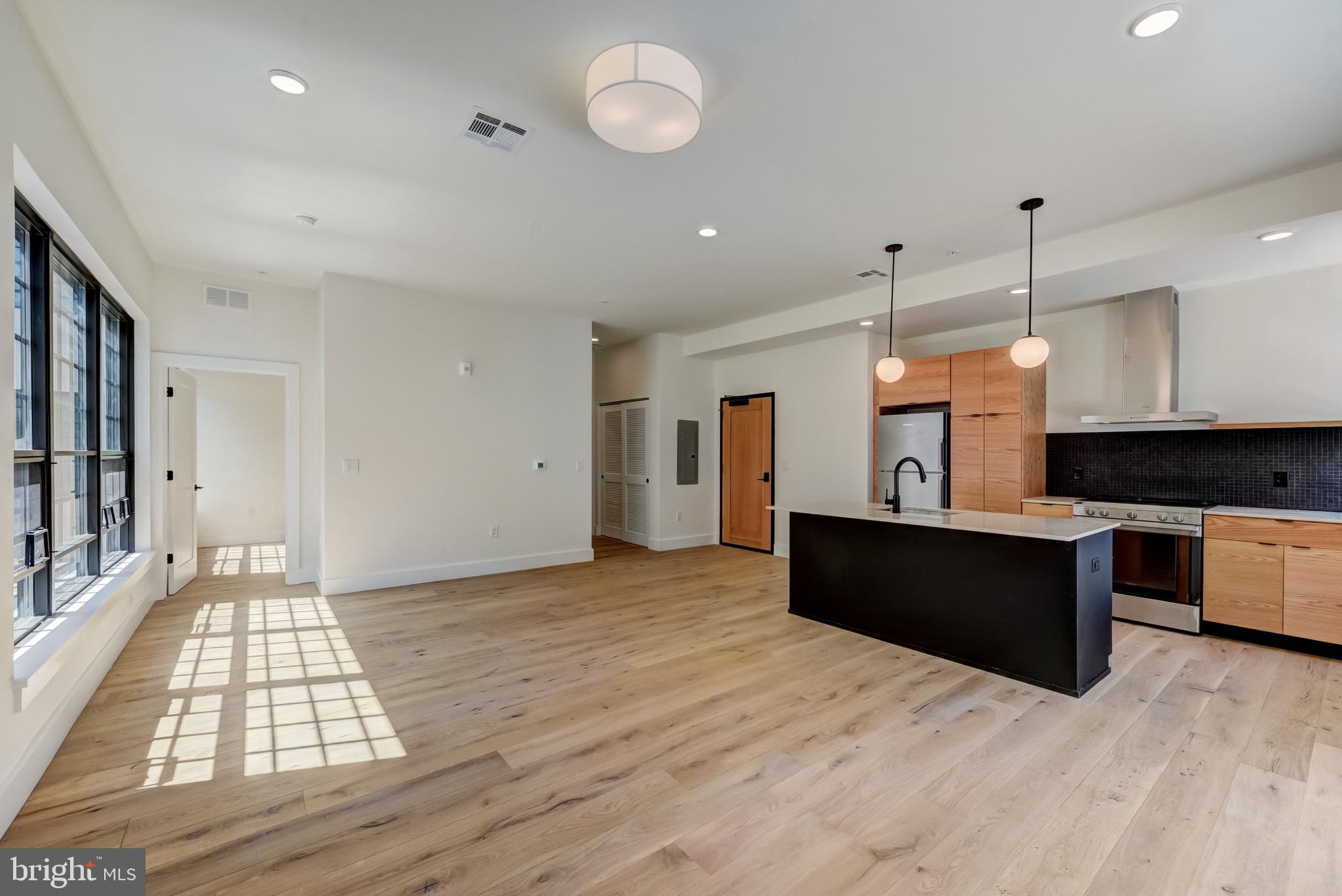 1701-15 North 2nd Street, Unit 606 Philadelphia, PA 19122 - Photo 30 of 47 a large kitchen with stainless steel appliances granite countertop a stove and a wooden floors