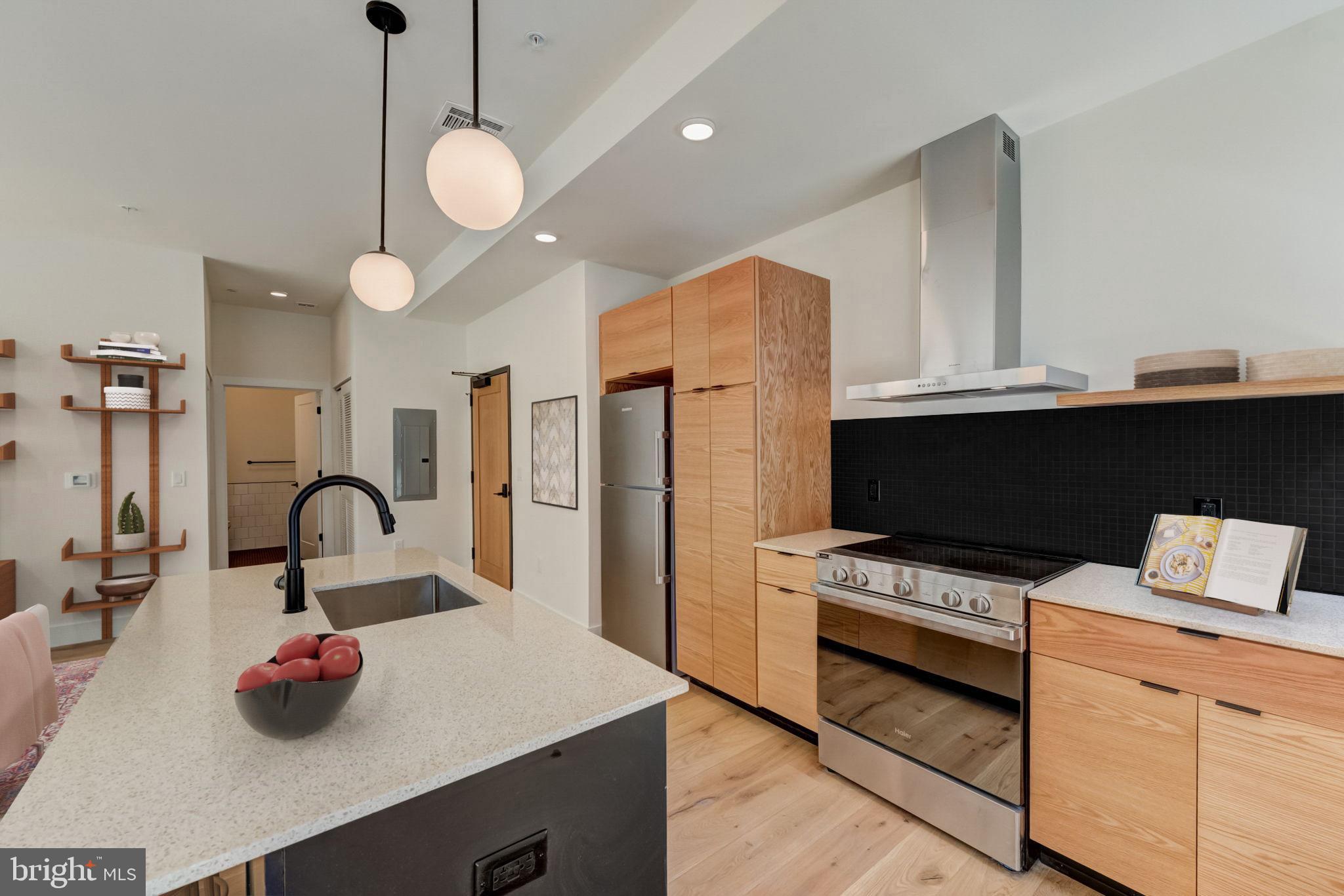 1701-15 North 2nd Street, Unit 606 Philadelphia, PA 19122 - Photo 3 of 47 a kitchen with granite countertop a stove a sink and a wooden floor