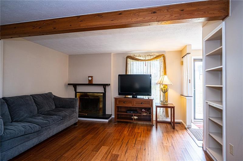 2531 Hunting Ridge Trail Bridgeville, PA 15017 - Photo 2 of 24 Living room log burning fireplace will keep you warm on chilly winter evenings whether you choose to watch TV or peruse through an offering from the built-in bookshelves.