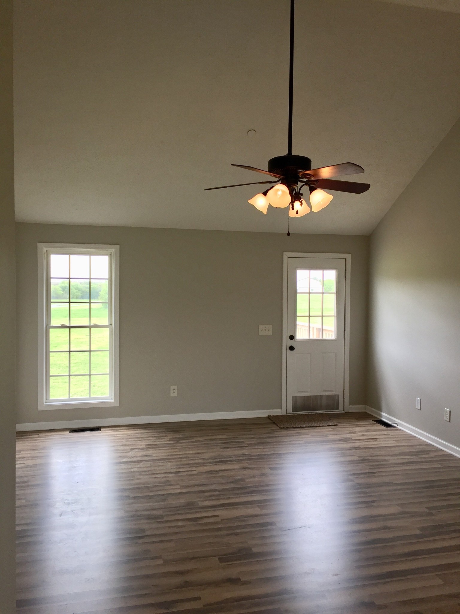 5722 Bill Anderson Road Portland, TN 37148 - Photo 4 of 11 an empty room with wooden floor chandelier fan and windows