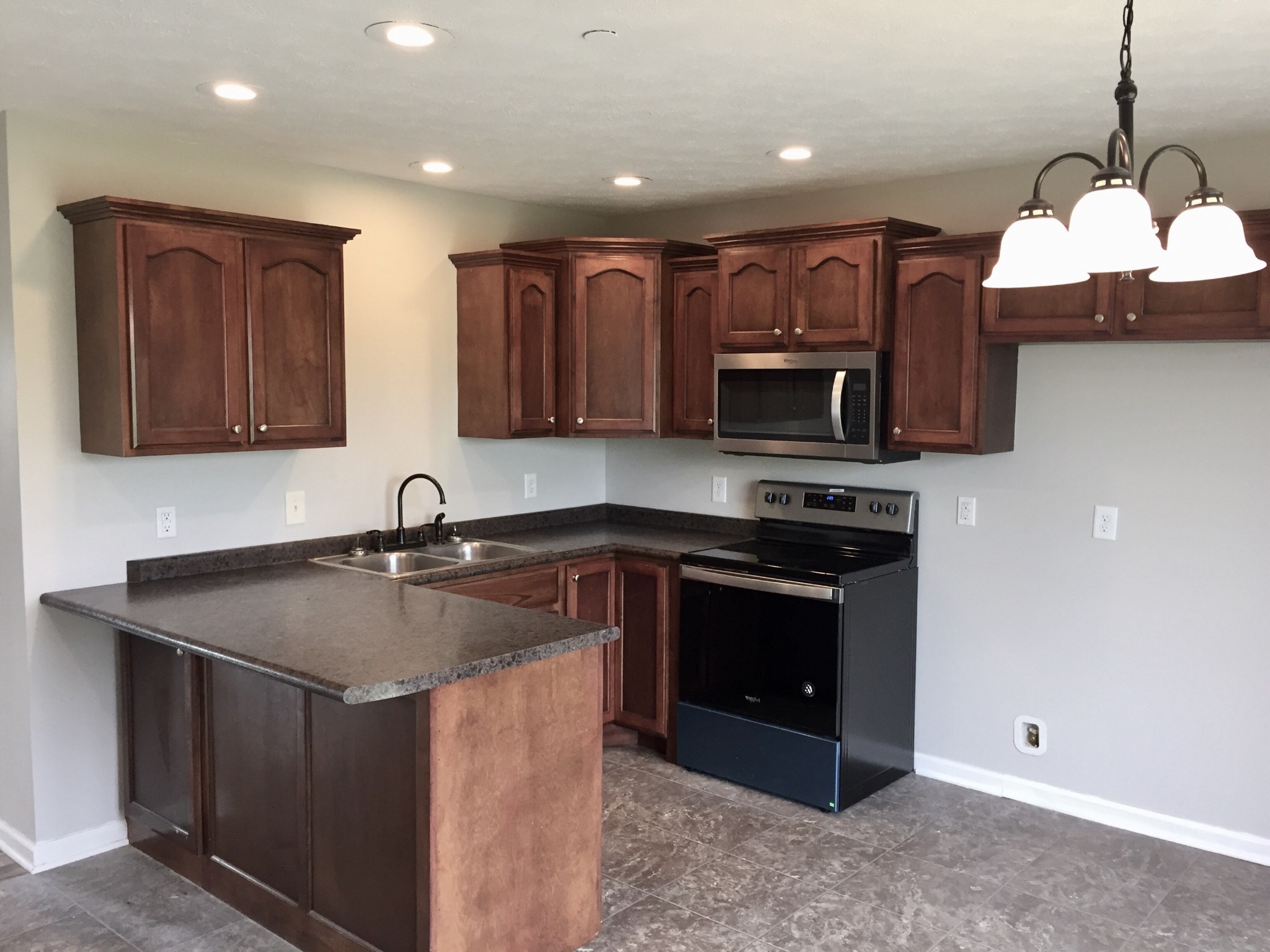 5722 Bill Anderson Road Portland, TN 37148 - Photo 6 of 11 a kitchen with stainless steel appliances granite countertop a stove a sink and a microwave