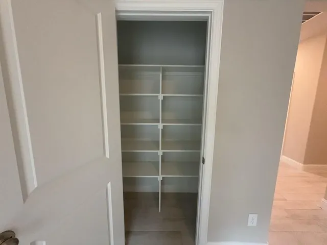 a view of walk in closet with empty racks