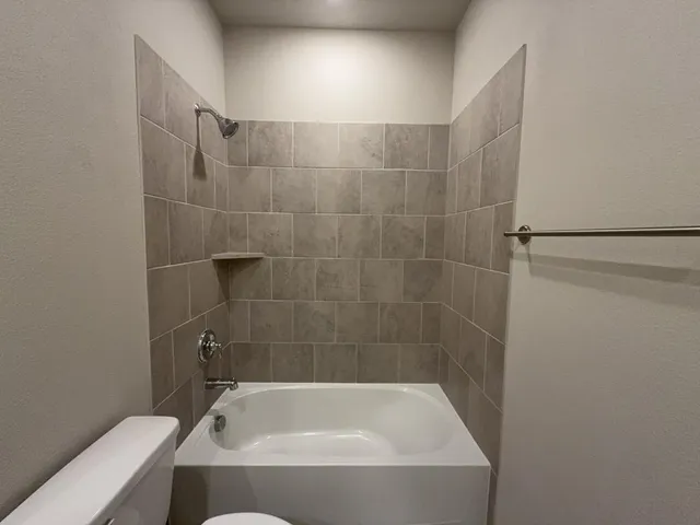 a white bath tub sitting next to a toilet