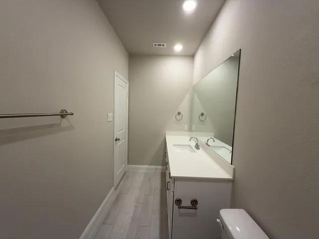 a bathroom with a sink mirror and toilet