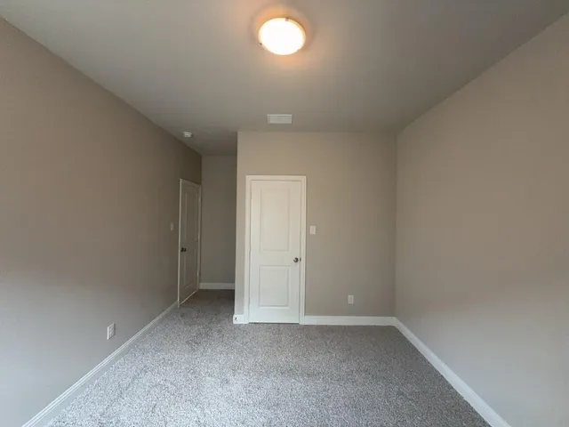 an empty room with a chandelier fan and window