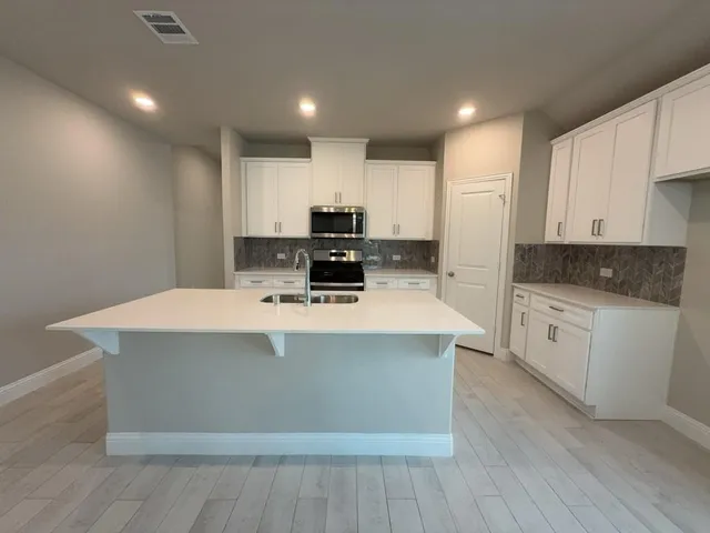 a view of kitchen with stainless steel appliances a stove top oven