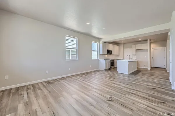 a view of empty room with wooden floor and window