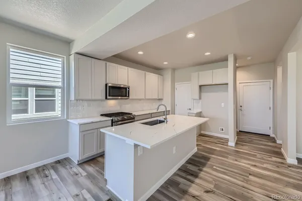 a kitchen with a stove a sink and a refrigerator
