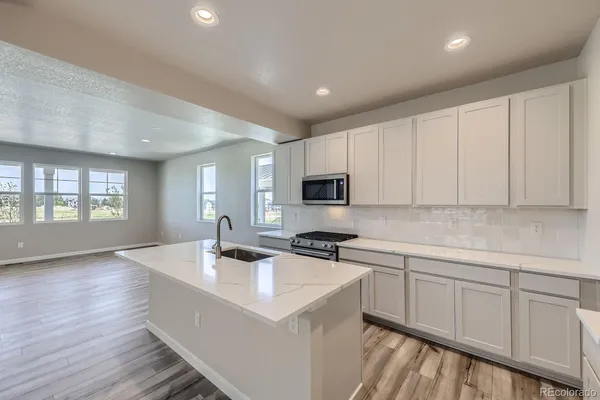 a kitchen with sink a microwave and cabinets