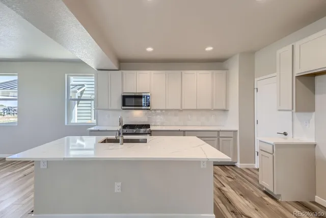 a kitchen with a sink a stove and cabinets