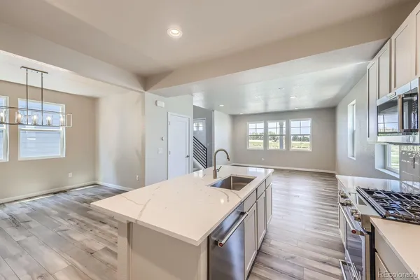 a kitchen with a stove a sink and a refrigerator
