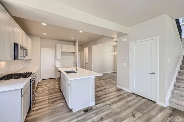 a kitchen with a stove a sink and a refrigerator