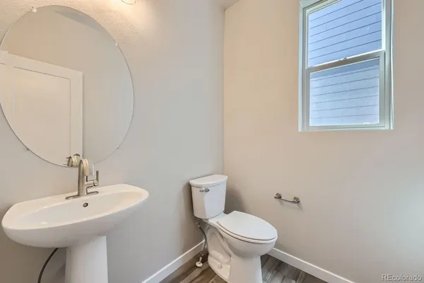 a bathroom with a toilet a sink and mirror
