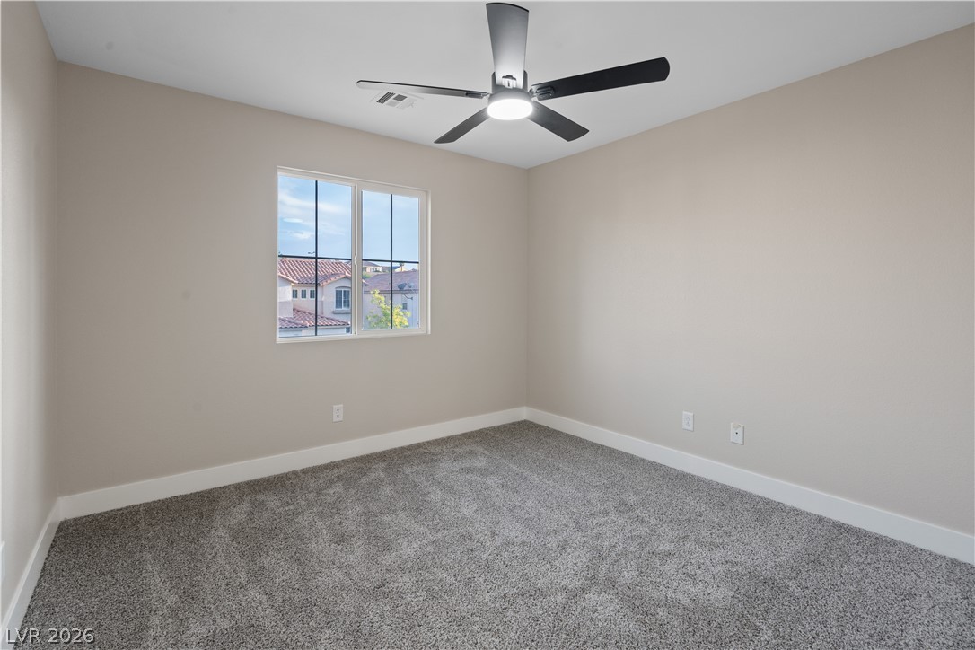 1662 Ravanusa Drive Henderson, NV 89052 - Photo 33 of 74 A well-lit bedroom provides comfort with its soft carpet and a cooling ceiling fan.