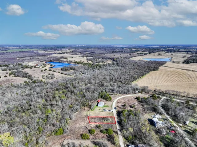 a view of a dry yard with wooden fence