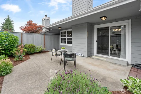 a backyard of a house with table and chairs
