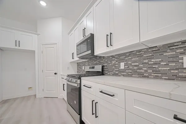 a kitchen with cabinets stainless steel appliances and a counter space