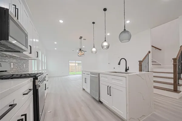 a kitchen with white cabinets and appliances