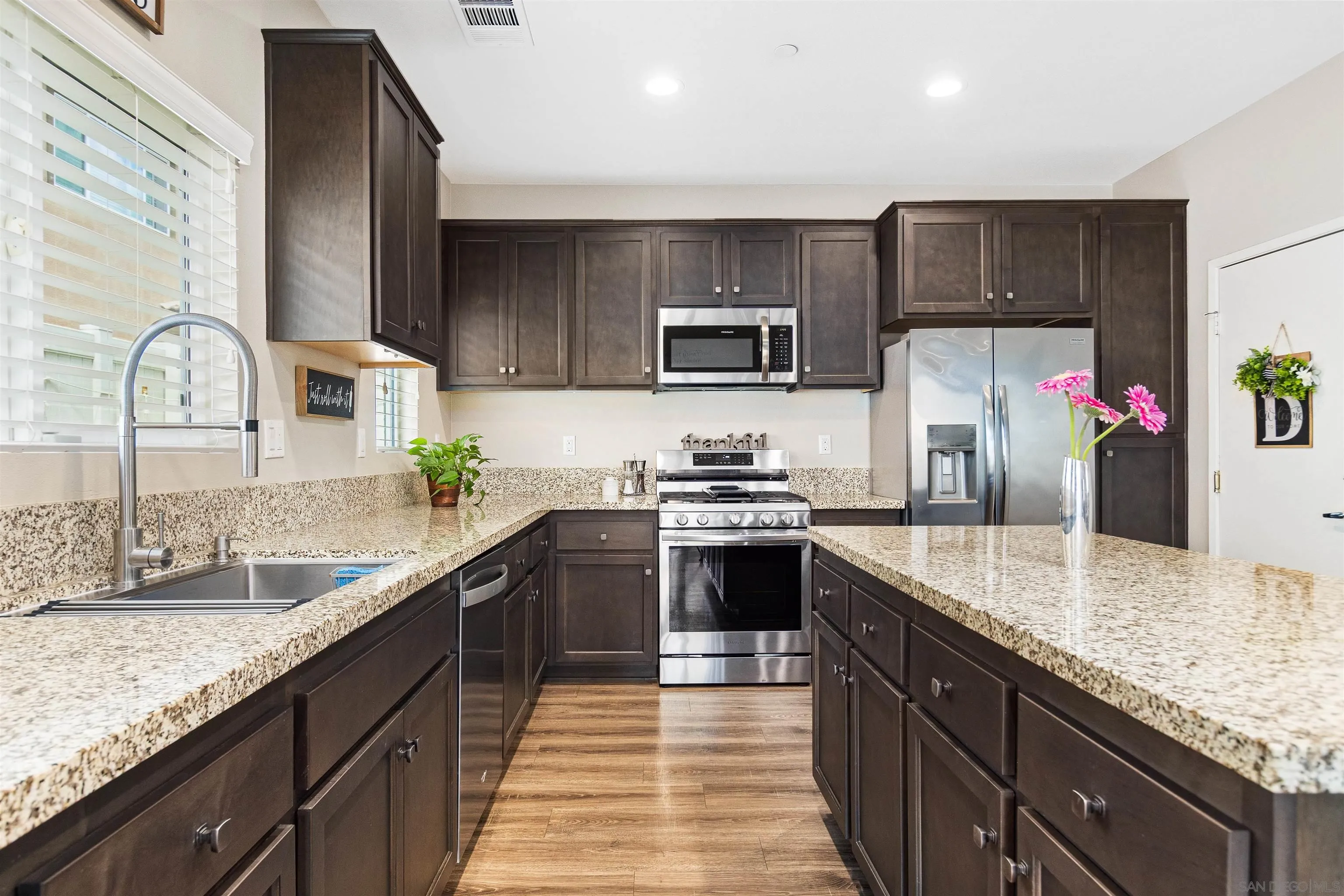 216 Oberlander Way Fallbrook, CA 92028 - Photo 4 of 31 a kitchen with kitchen island granite countertop a sink stove and cabinets
