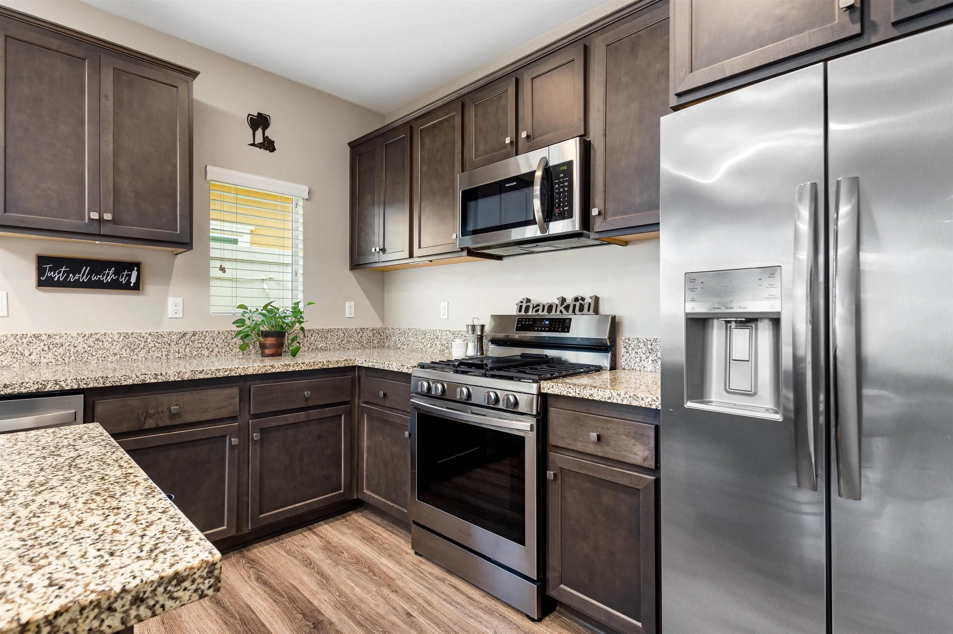 216 Oberlander Way Fallbrook, CA 92028 - Photo 7 of 31 a kitchen with stainless steel appliances granite countertop a stove a refrigerator and a microwave