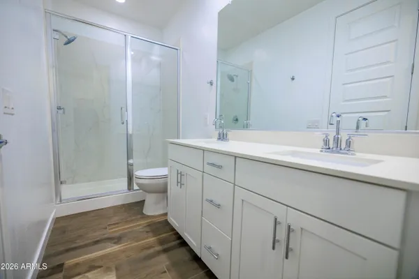 a spacious bathroom with a shower sink vanity mirror and toilet