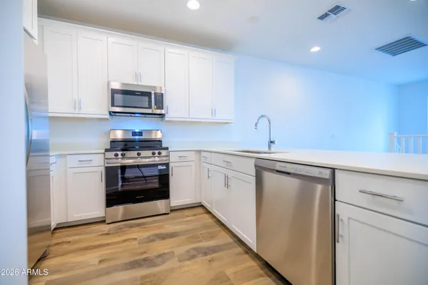 a kitchen with stainless steel appliances a stove sink and cabinets