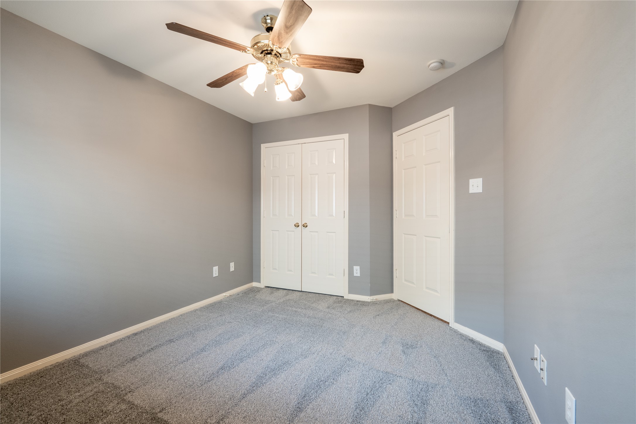 10619 Crownsedge Drive Spring, TX 77379 - Photo 22 of 38 This is a cozy, freshly painted bedroom with soft gray walls and carpeted flooring. It features a ceiling fan for comfort and a double-door closet for storage.