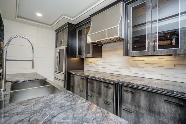 a kitchen with granite countertop a refrigerator and a sink