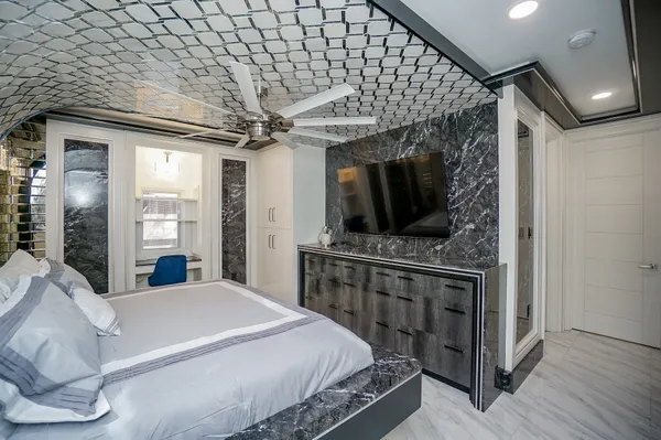 a bedroom with a large bed and a flat tv screen on a dresser