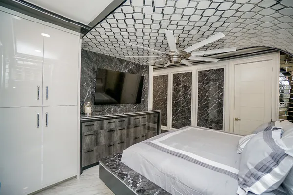 a bedroom with a large bed and a flat tv screen on a dresser