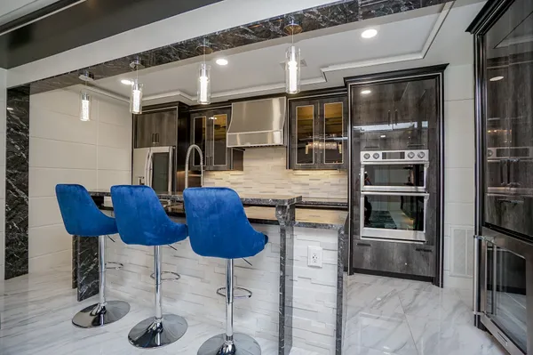a kitchen with stainless steel appliances kitchen island granite countertop a table chairs in it and wooden floors