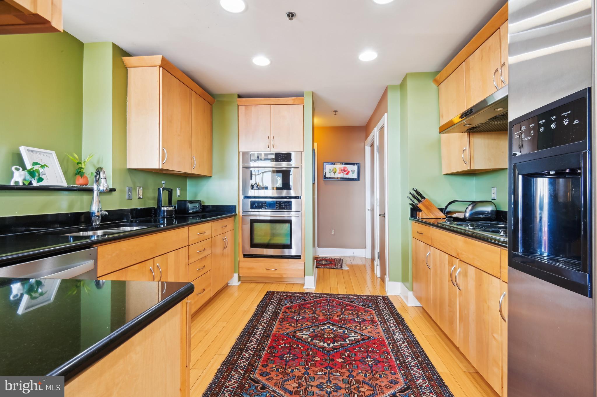 1400 Lancaster Street, Unit 605 Baltimore, MD 21231 - Photo 16 of 44 a large kitchen with stainless steel appliances granite countertop a refrigerator a stove top oven and a sink