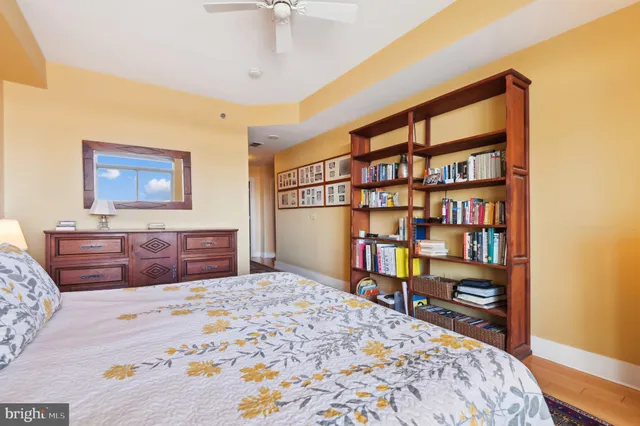 a bedroom with a bed a dresser and book shelf