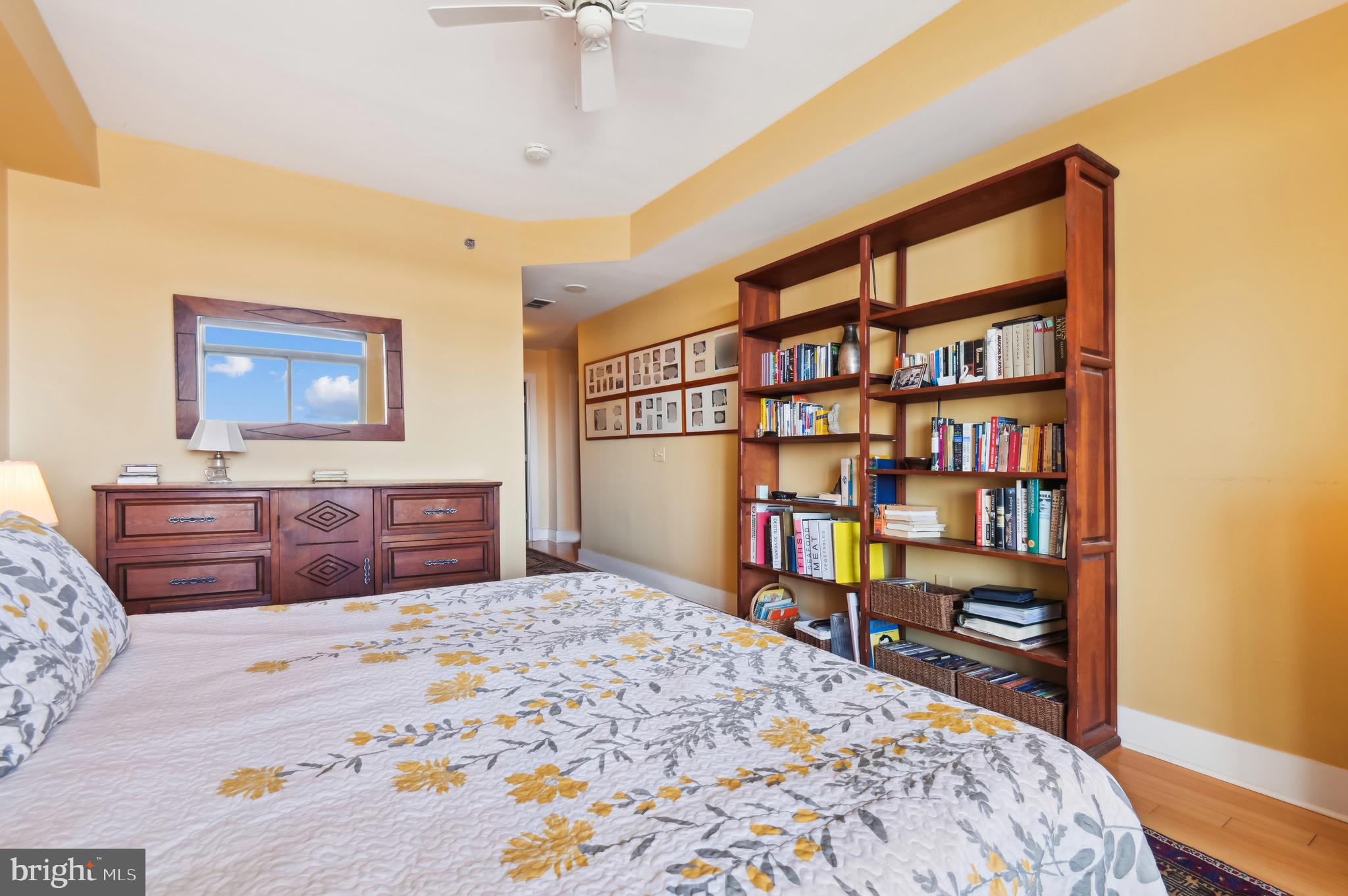 1400 Lancaster Street, Unit 605 Baltimore, MD 21231 - Photo 28 of 44 a bedroom with a bed a dresser and book shelf