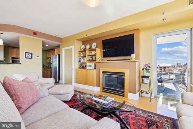 a living room with furniture a flat screen tv and a fireplace