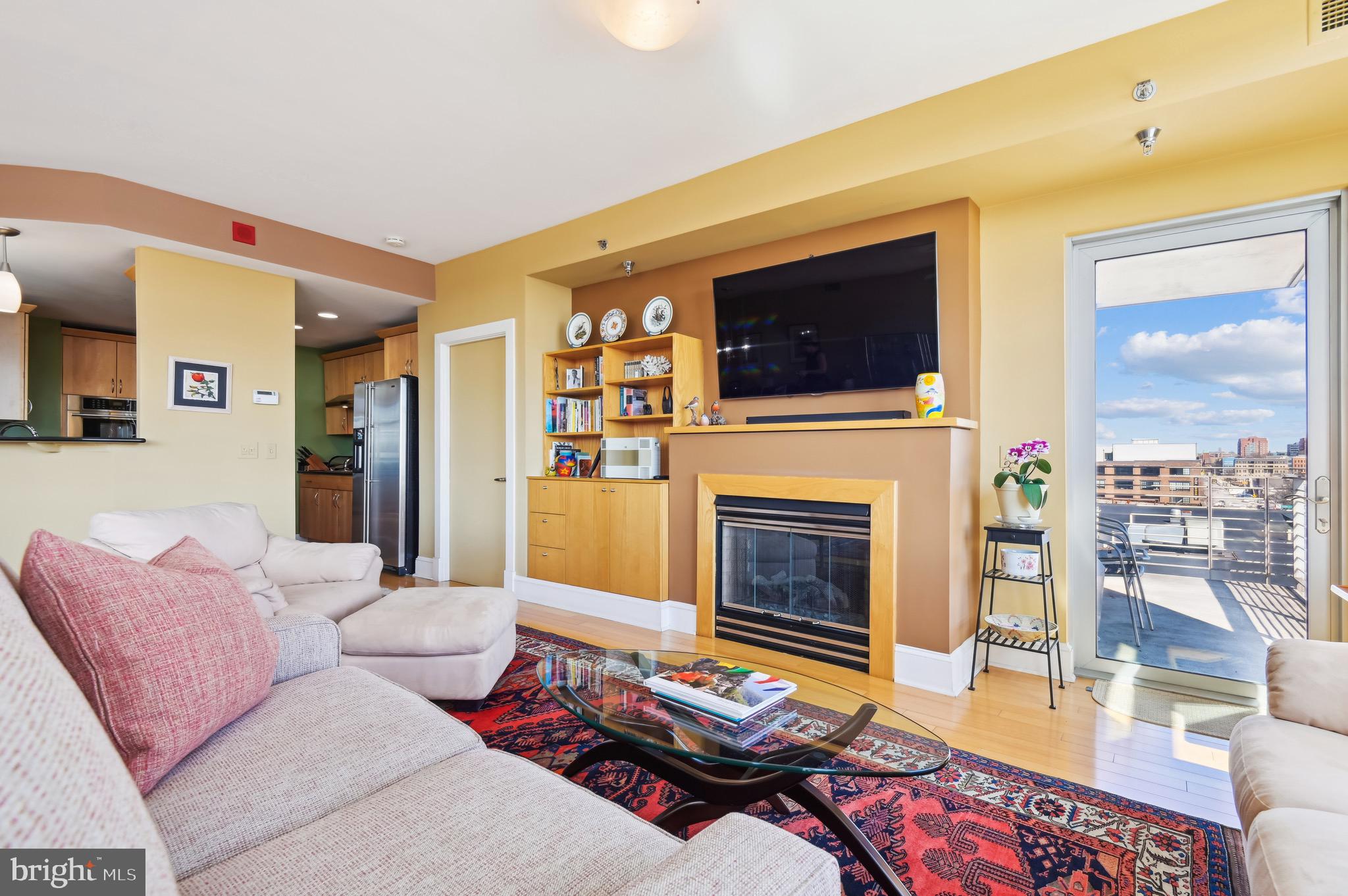 1400 Lancaster Street, Unit 605 Baltimore, MD 21231 - Photo 10 of 44 a living room with furniture a flat screen tv and a fireplace
