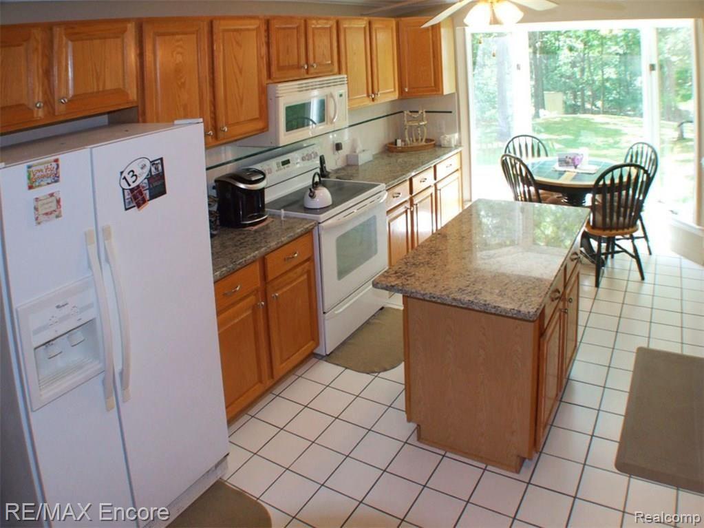 9965 Bridge Lake Road Clarkston, MI 48348 - Photo 7 of 34 Kitchen with island and nook with great view of the wooded lot