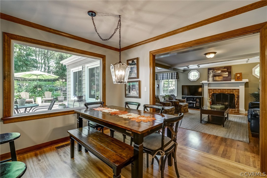 2021 Thornleigh Road Midlothian, VA 23113 - Photo 12 of 49 a dining room with wooden floor a chandelier a wooden table and chairs