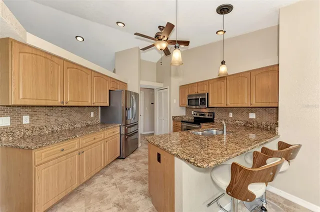 a kitchen with kitchen island granite countertop a stove a sink and a granite counter tops