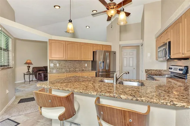 a kitchen with kitchen island a counter top space appliances and cabinets