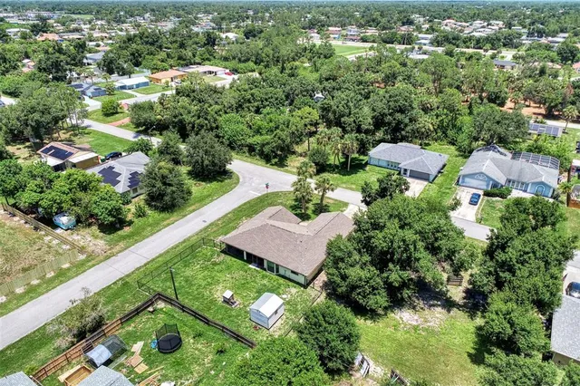 an aerial view of a house with a yard and trees