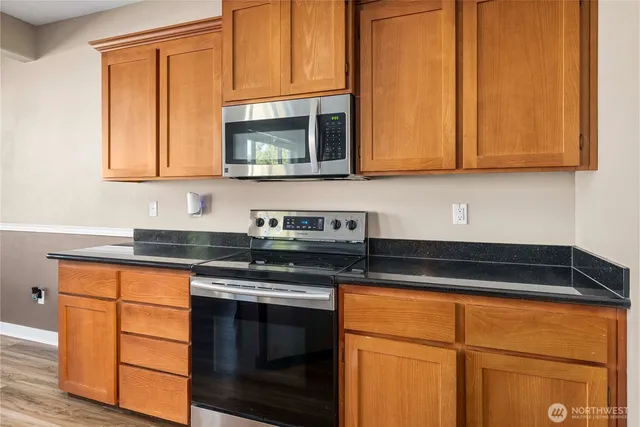 a kitchen with stainless steel appliances granite countertop wooden cabinets and a granite counter tops