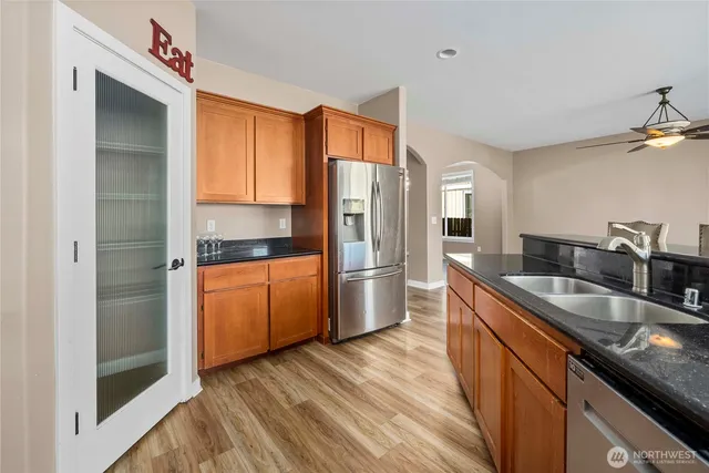 a kitchen with stainless steel appliances granite countertop a sink a stove and a refrigerator