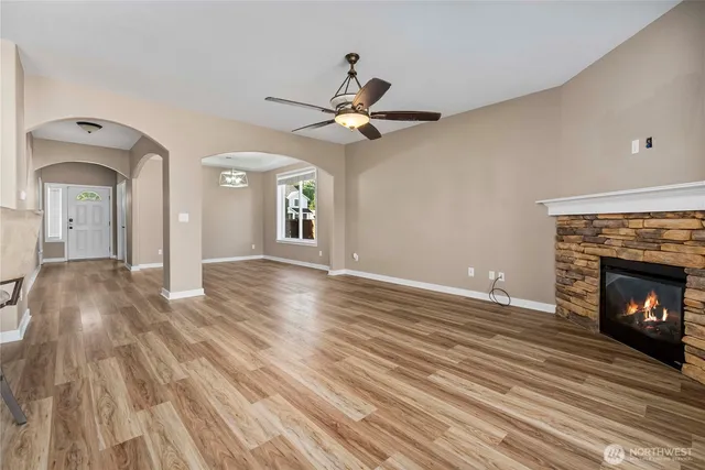 a view of livingroom with fireplace chandelier fan and wooden floor