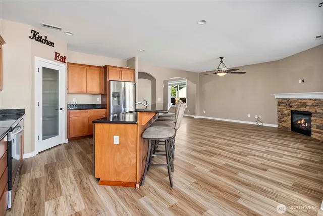 a view of a living room and kitchen with furniture wooden floor and windows