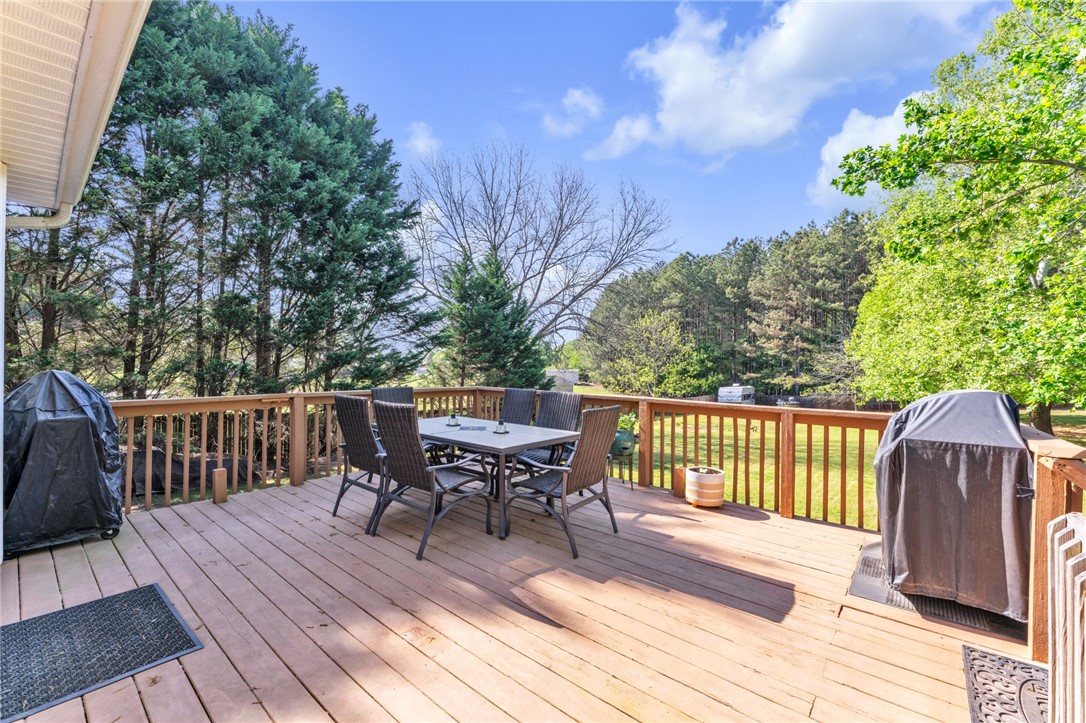 154 Hammond School Road Anderson, SC 29621 - Photo 24 of 33 Enjoy outdoor living and dining on this expansive wooden deck with a scenic backyard view.